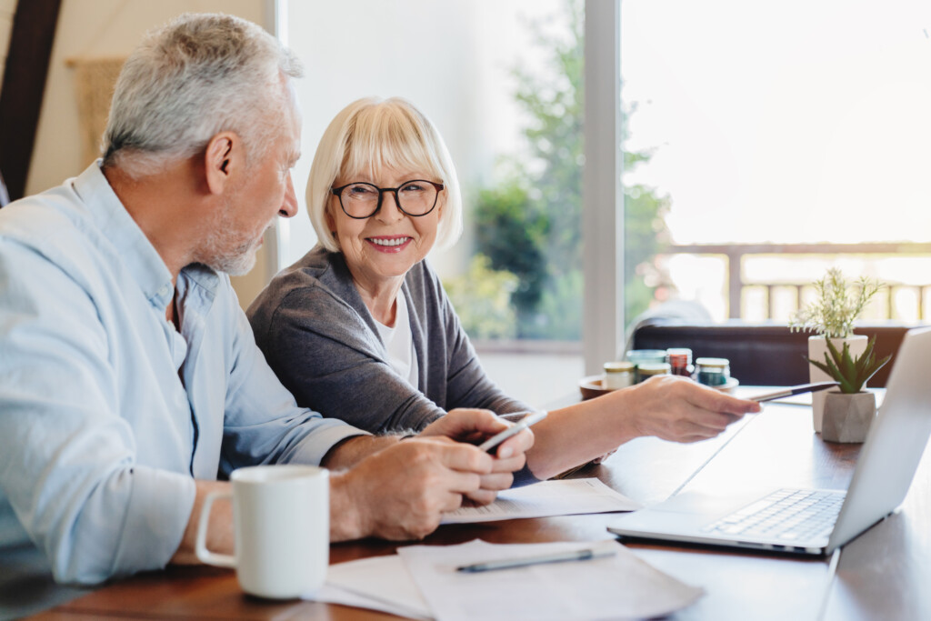 Couple doing home finances using laptop indoors